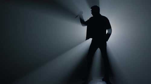Sinister Silhouette Holding a Knife in the Dark