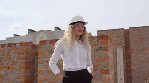 Uma arquiteta em trajes de negócios fica no último andar ao ar livre em um canteiro de obras