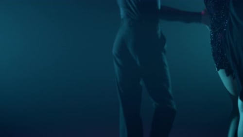 Young Man and Woman Dancing on Dark Stage