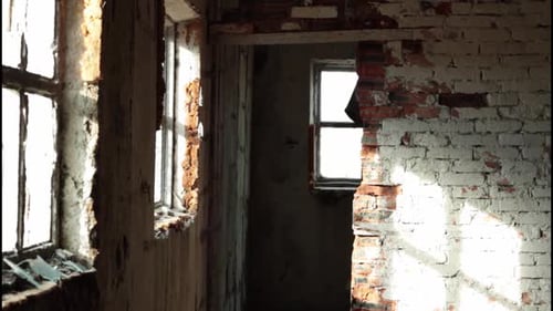 a Man in a Long Cloak with a Hood Walks in an Abandoned Building with Bloody Ax