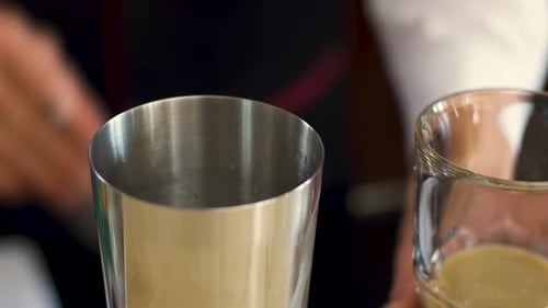 Bartender Mixing Drink in Silver Cocktail Shaker