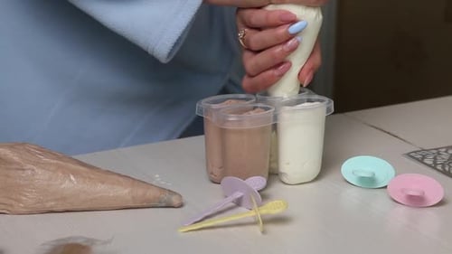A Woman Fills An Ice Cream Mold With Buttercream.