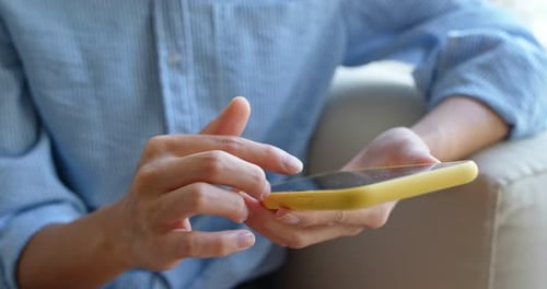 Adult Using Mobile Phone At Home Close Up