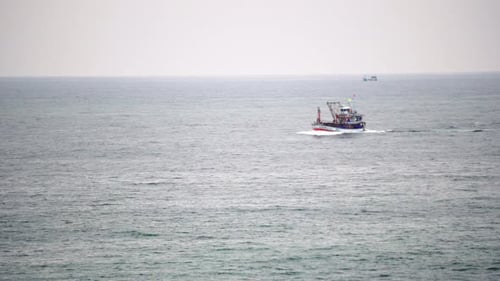 A Ship Crosses the Bay in A Calm Sea. Azure Ocean and Blue Sky Merge on The Horizon