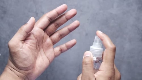 Applying Sanitizer to Hands with Spray Bottle