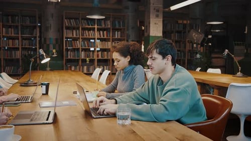 Concentrated Diverse Millennial Students Work with Information at Public Library