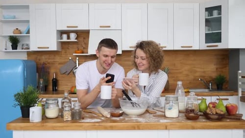 Young Couple Relaxing Together Cooking in Kitchen