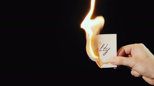 Man Burns a Paper with the Inscription Loyalty