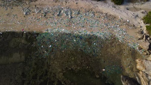 Beautiful tourist beach of Ninh Thuan in Vietnam completely covered with colored plastic waste and p