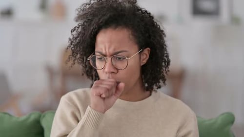 Young Woman Coughing into Fist Close Up