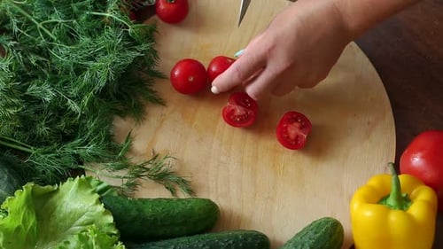 Woman Slicing Tomatoes on Wooden Cutting Board