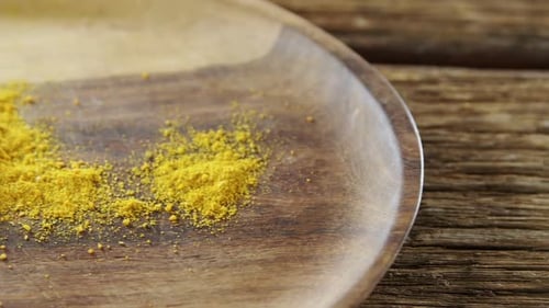 Turmeric powder in spoon on a plate 4k