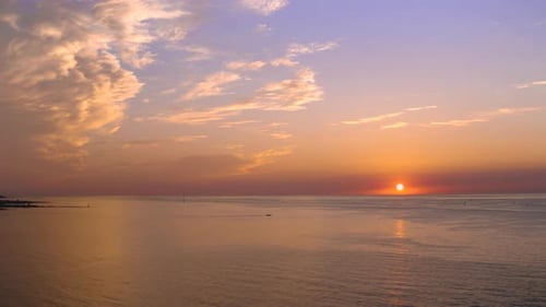 The romantic scene of the sun setting on the horizon of the vast ocean. Drone sh