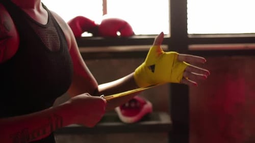 Close up of a female boxer wrapping hands with boxing wraps