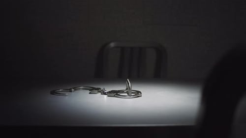 Handcuffs on Table in Dimly Lit Room