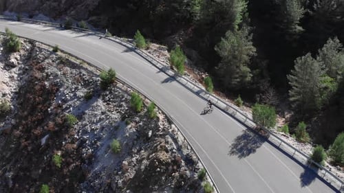 Cyclist Rides Along Mountain Road Aerial View