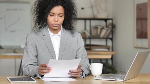 Woman Reviews Documents in Bright Office