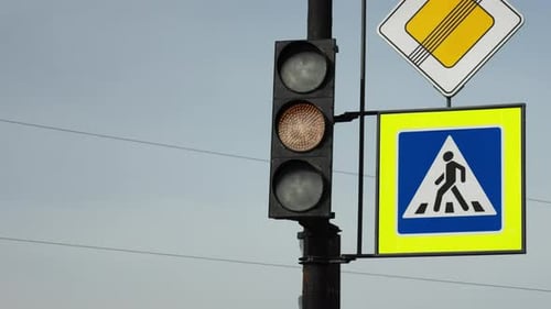 Eine Ampel mit Hinweisschildern für Fußgänger zählt die Zeit zum Einschalten des grünen Signals herunter