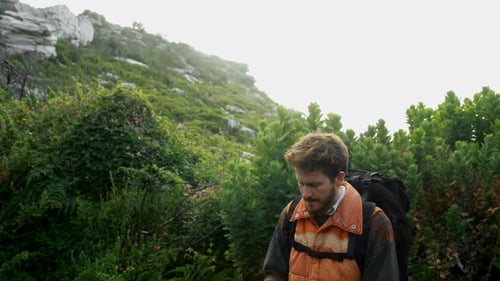 Man with Backpack Taking Mountain Pictures with Phone