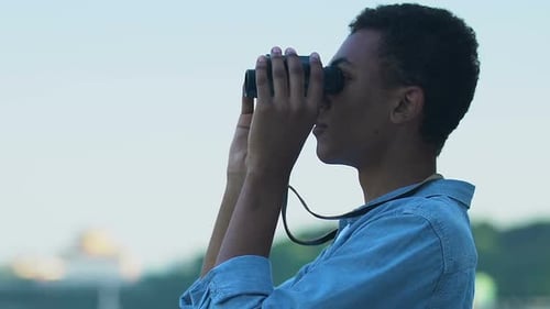 Young Adult Uses Binoculars Outdoors