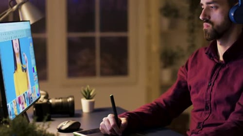 Graphic Designer Working at Computer With Tablet at Night