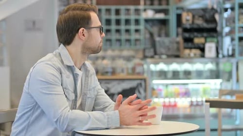 Anxious Man Checking Time While Waiting in Cafe