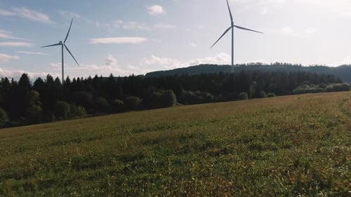 Aerial Drone Shot of Wind Turbines in the Forest Near the Sea at Sunset.