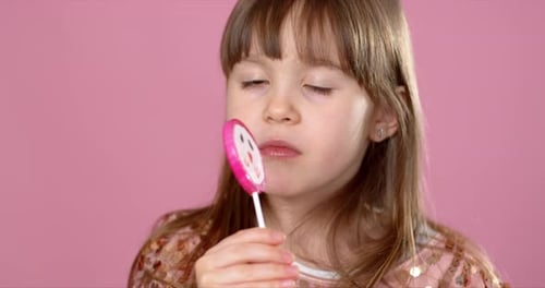 Happy Little Girl Enjoying a Colorful Lollipop