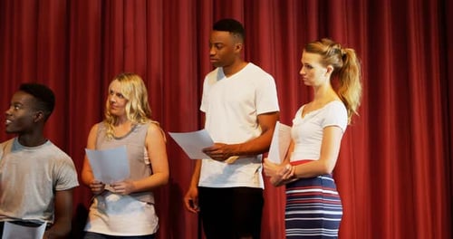 Actors Rehearse Play on Stage With Red Curtain