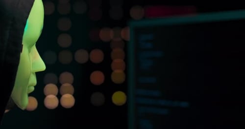 Masked Figure Typing at Computer at Night