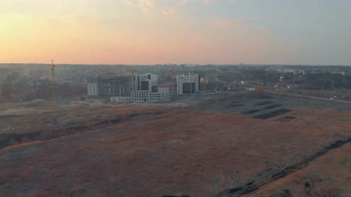 Construction Cranes Near City Buildings at Sunrise