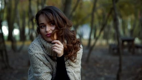 Woman relaxing in park. Happy attractive woman relaxing in sunny autumn park