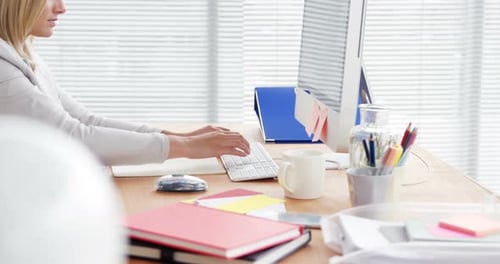 Woman Typing at Computer in Bright Modern Office