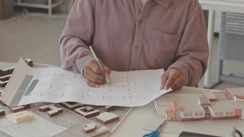 Architect Taking Notes in Building Plan