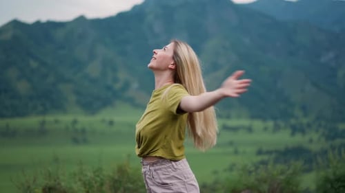Cheerful Woman Spins Around Over Large Valley Against Hills