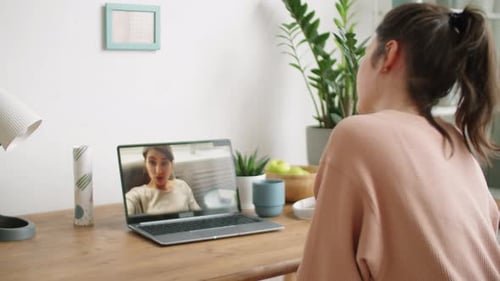 Woman Video Conferencing with Friend Demonstrating Skin Care