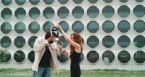 A guy and a girl experimenting and trying virtual reality in the city center