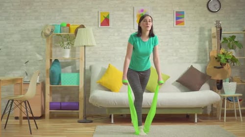 Young Woman Exercises With Resistance Band at Home