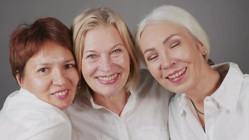 Studio Portrait of Three Mature Girlfriends Smiling at Camera