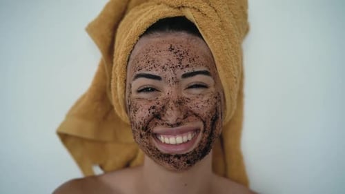 Woman Applies Dark Facial Scrub with Makeup Brush