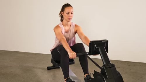 Woman on Rowing Machine Indoors Doing Workout