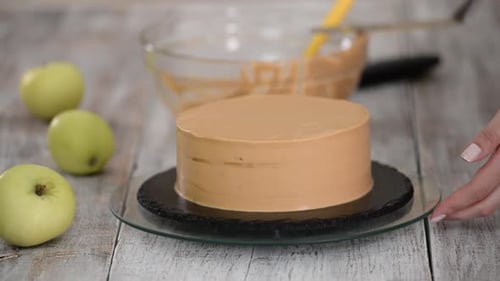 Woman Frosting Delicious Cake at Table