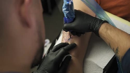Tattoo Artist Creating Tattoo Design on Arm
