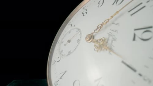 Antique Pocket Watch with a White Dial and Gold Moving Hands on Black Isolated Studio Background