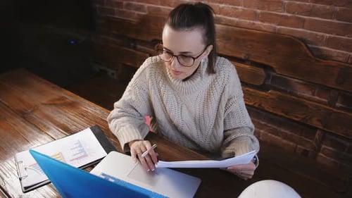 Workflow Construction Engineer in Front of a Laptop and Paper