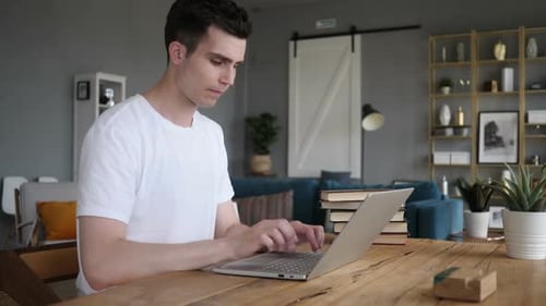 Adult Working on Laptop Frustrated at Home