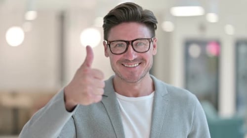 Man Giving Thumbs Up in Modern Office
