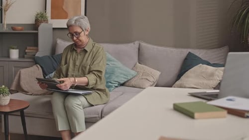 Woman Working on Tablet on Couch at Home