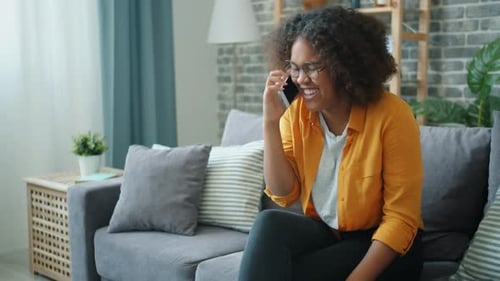 Smiling Young Woman Talking on Phone Indoors