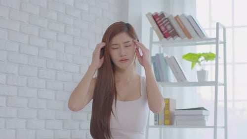 Young Woman Rubbing Temples Experiencing Headache